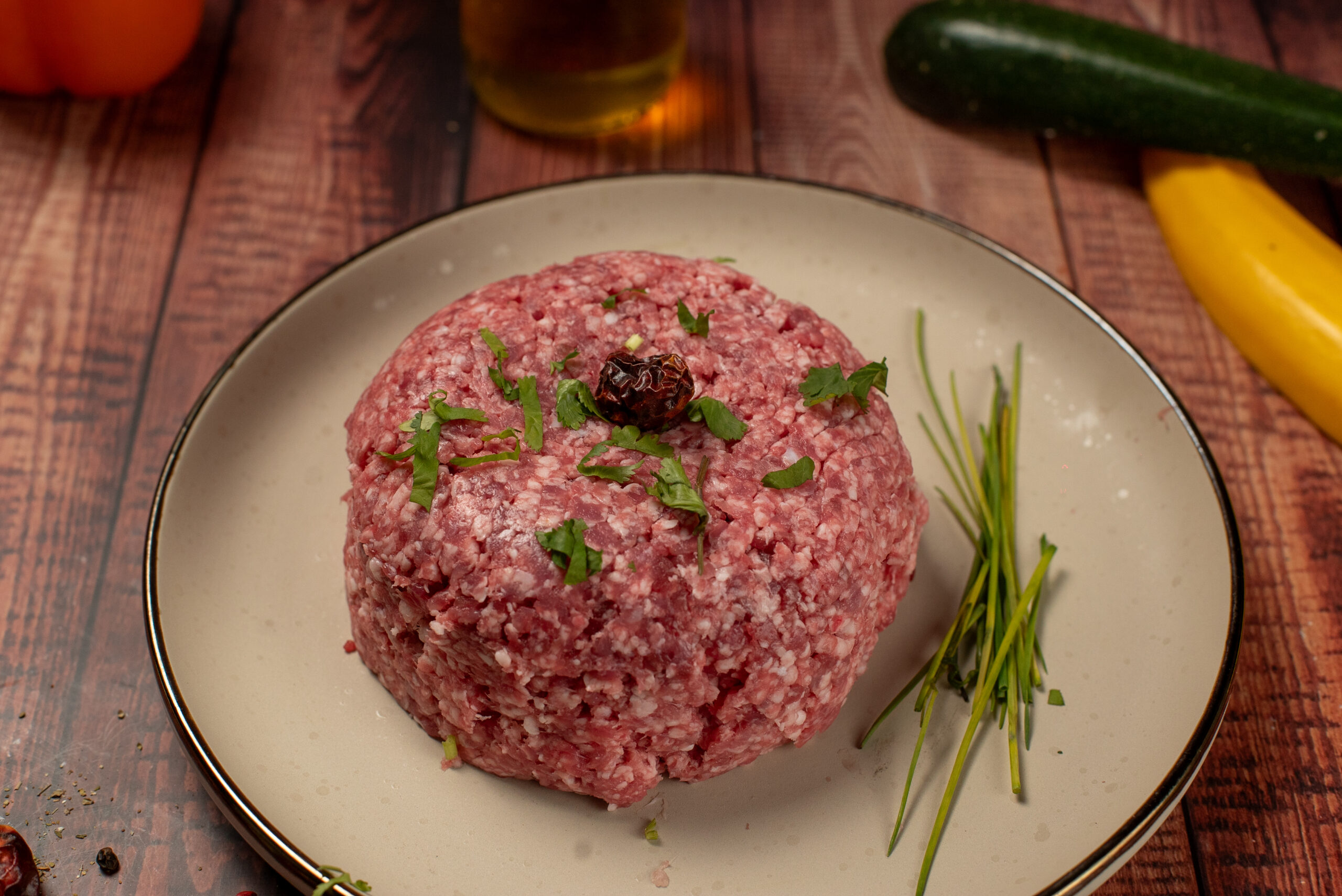Fresh halal lamb mince portion garnished with herbs on plate